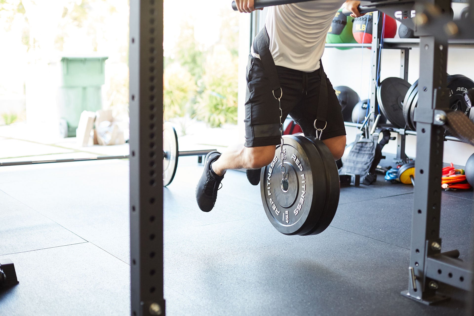 Lifter using the REP Dip Belt to perform weighted dips in a garage gym.