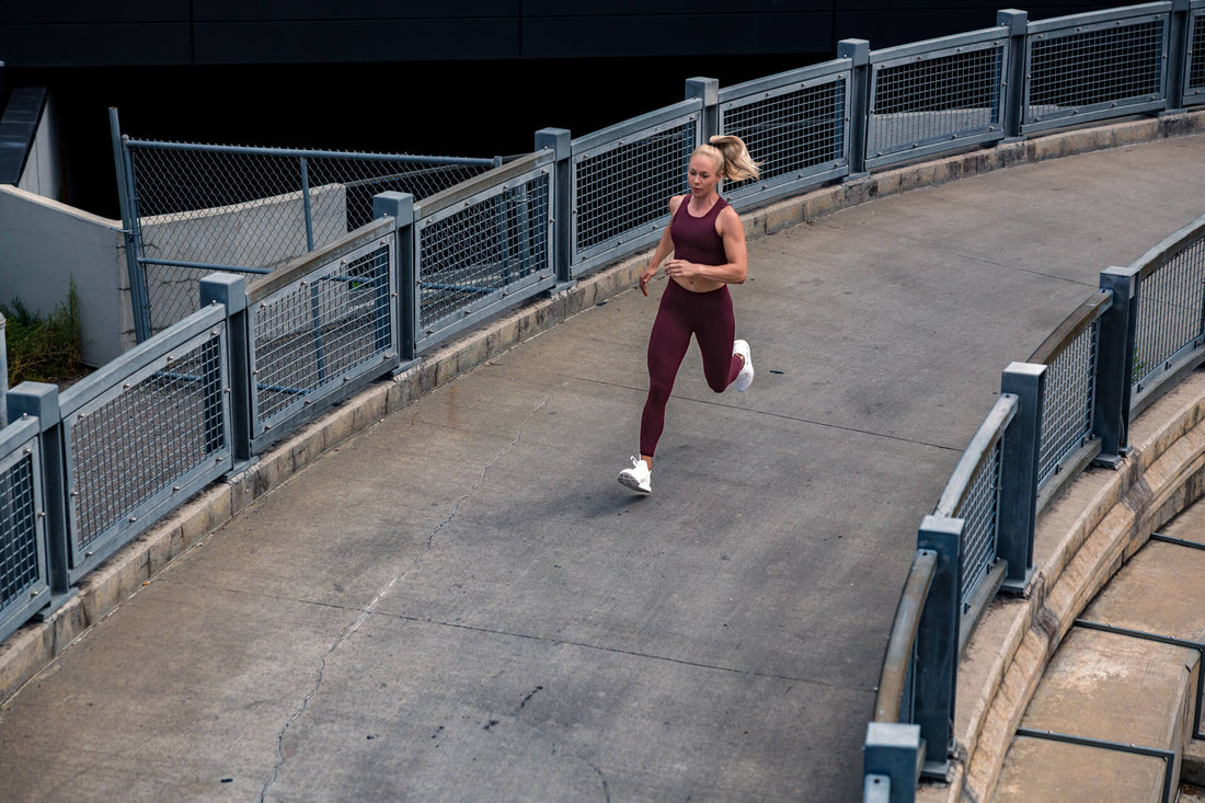 A woman runs across a bridge in Eos Tights.