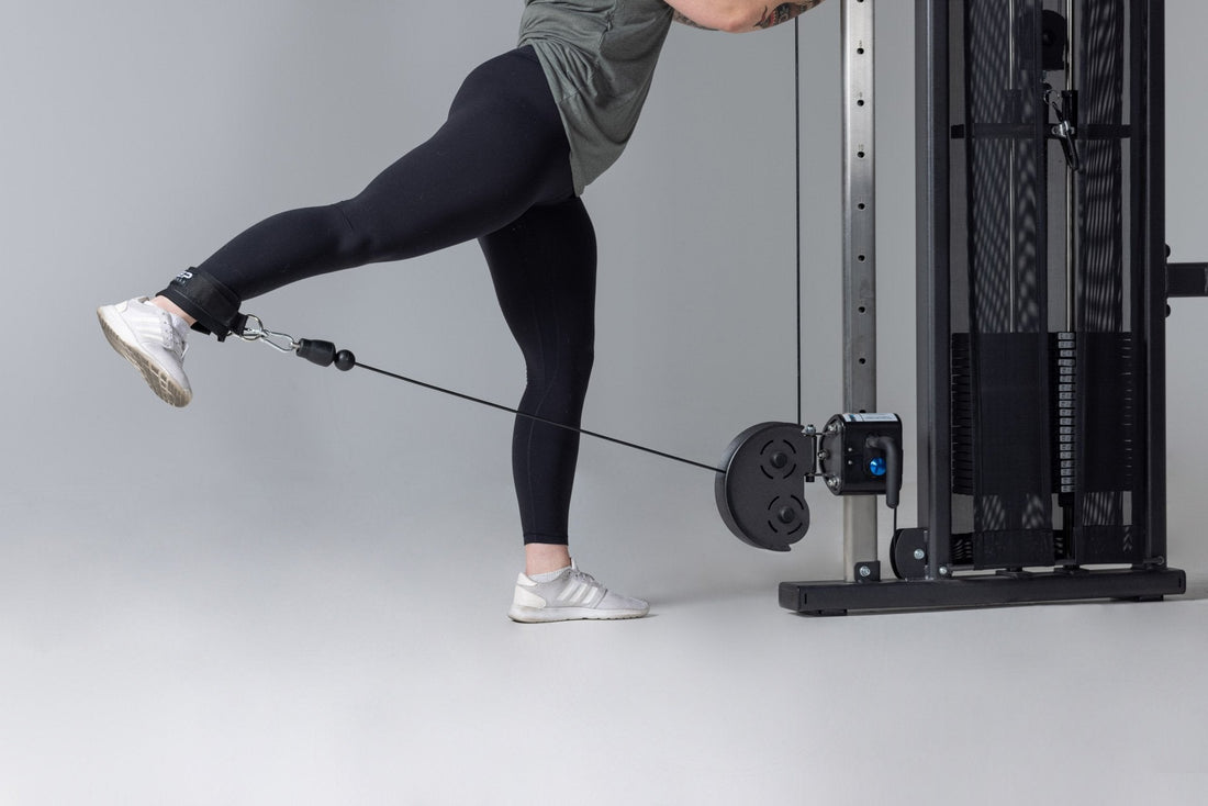 Athlete does a kickback on a cable machine.