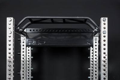 Close up of the stamped Logo Plate Crossmember 2.0 on a REP power rack in front of a black background